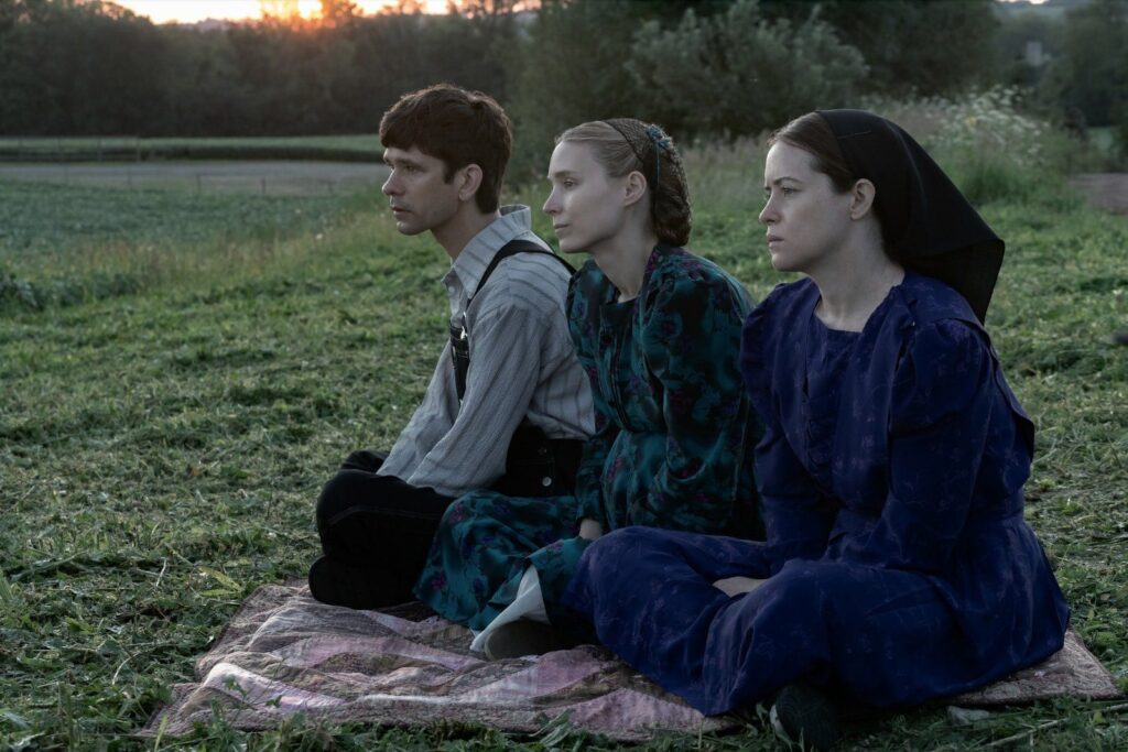 August, Ona y Salome sentados en pasto viendo al horizonte