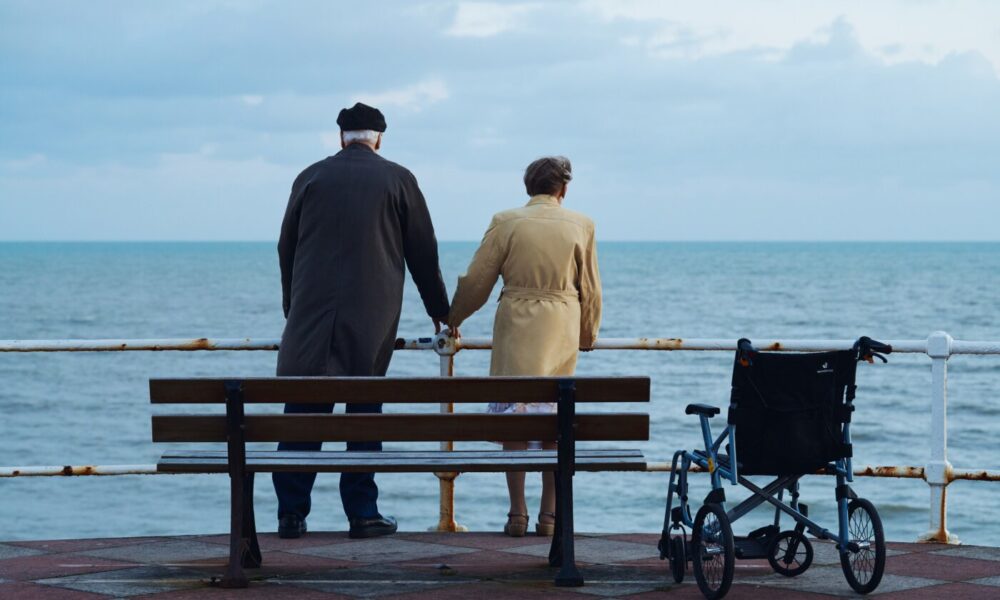 Bernard e Irene agarrados de la mano viendo al horizonte